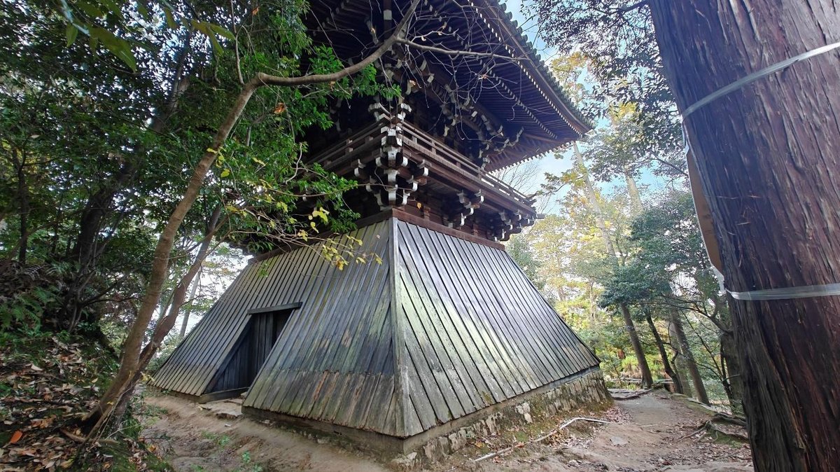Traditional Japanese wooden pagoda in lush forest setting