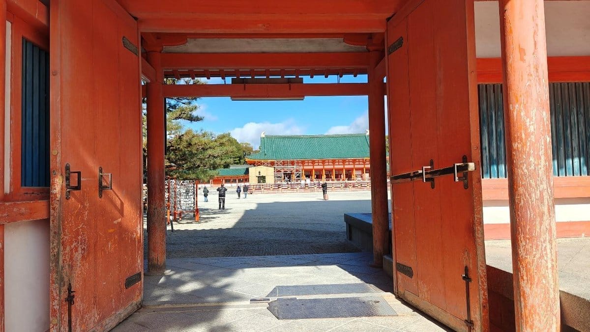 Traditional red gate framing a temple courtyard