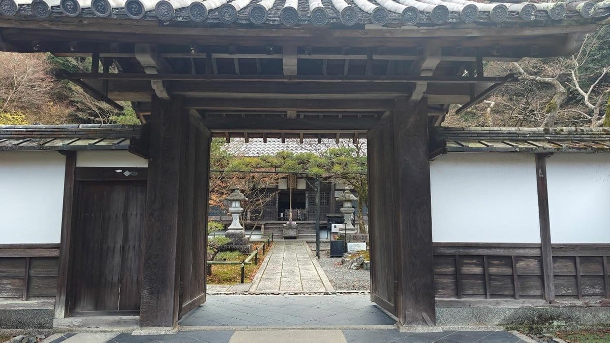 Traditional wooden gate leads to serene Japanese garden