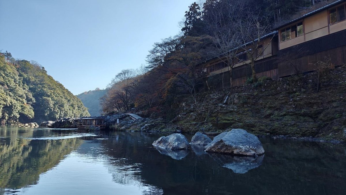 Tranquil river with trees and hillside residence