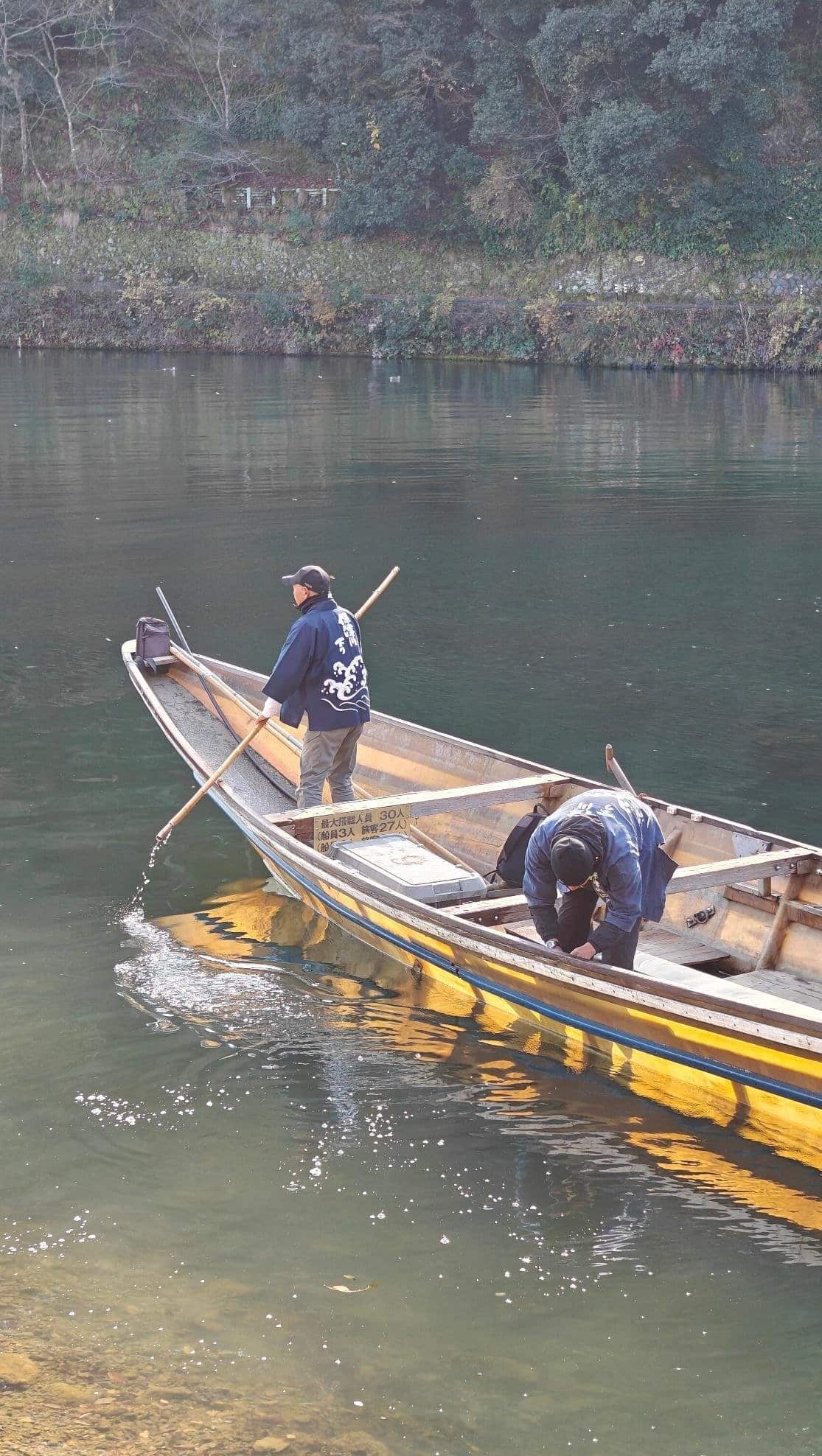 Two people in a wooden boat on a tranquil river