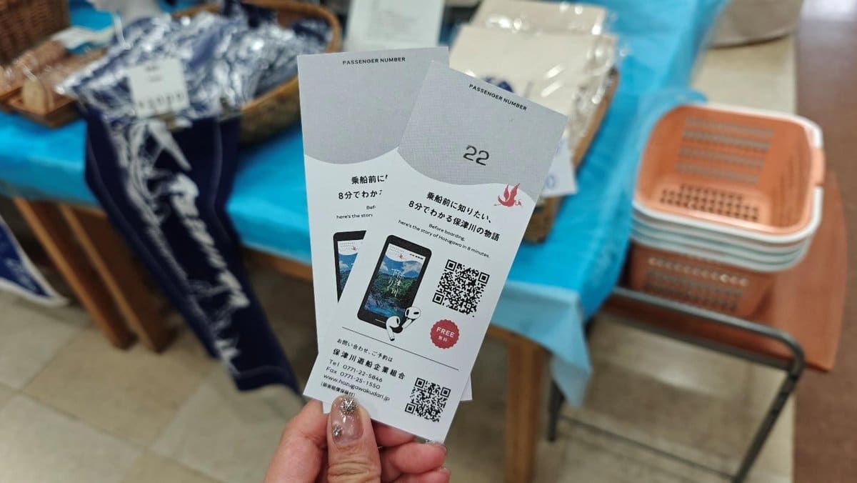 Two tickets held in hand above a table with baskets