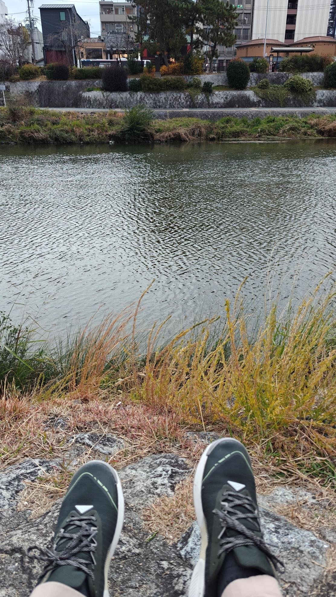 Urban river view with shoes in foreground
