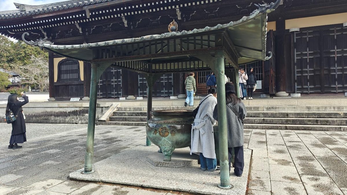 Visitors at an ancient temple with incense burner