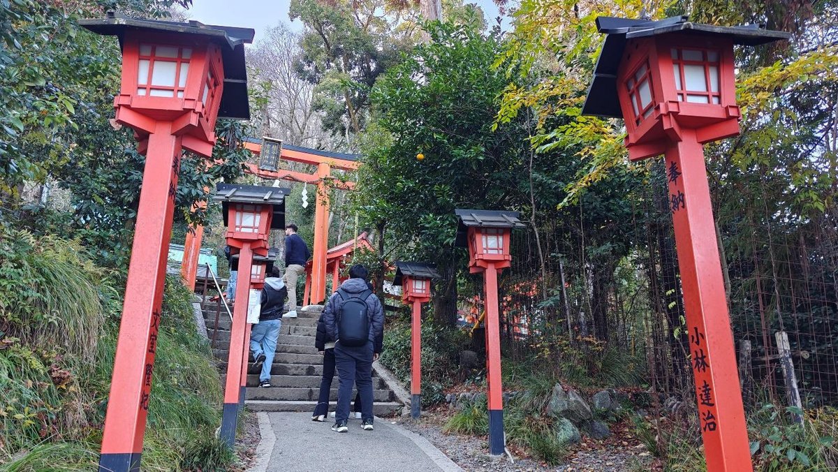 Visitors at shrine steps with red lamps