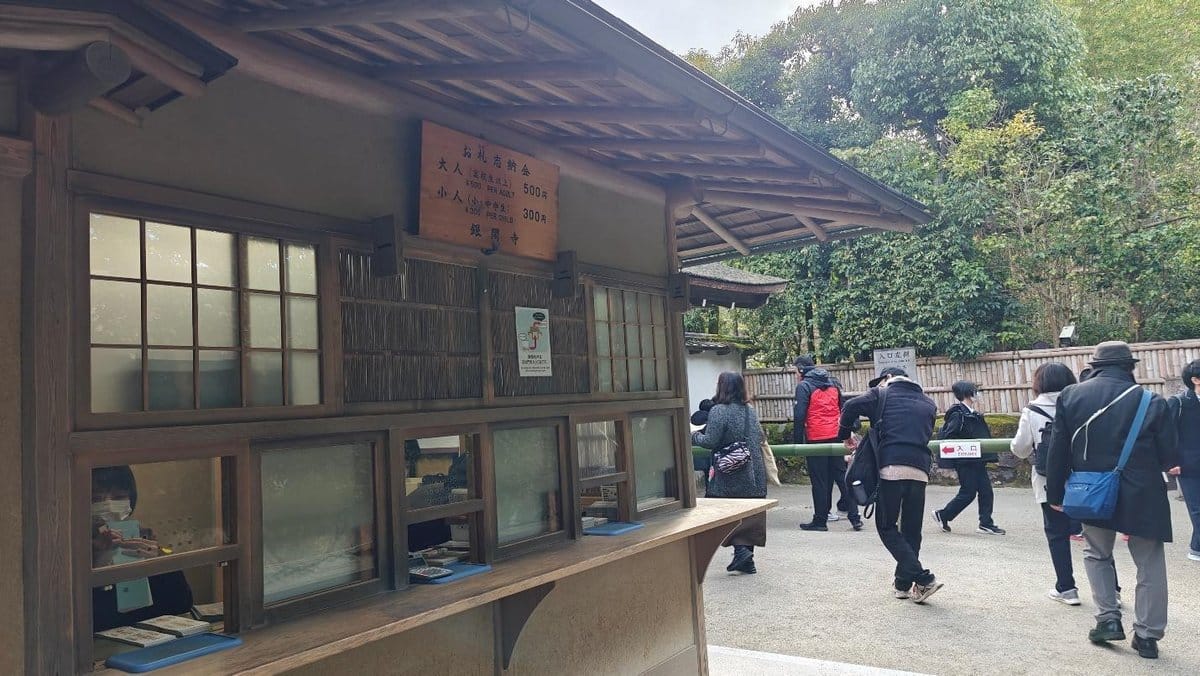 Visitors near traditional Japanese ticket booth