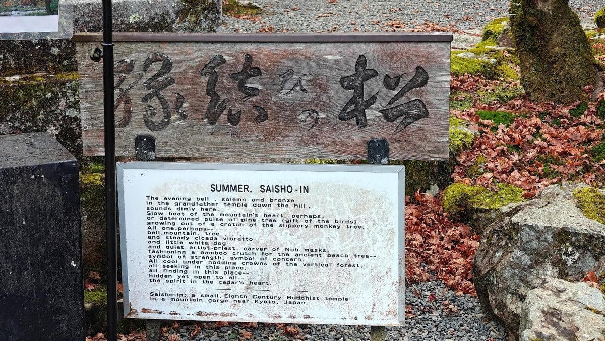 Weathered wooden signboard with Japanese text and poetry plaque