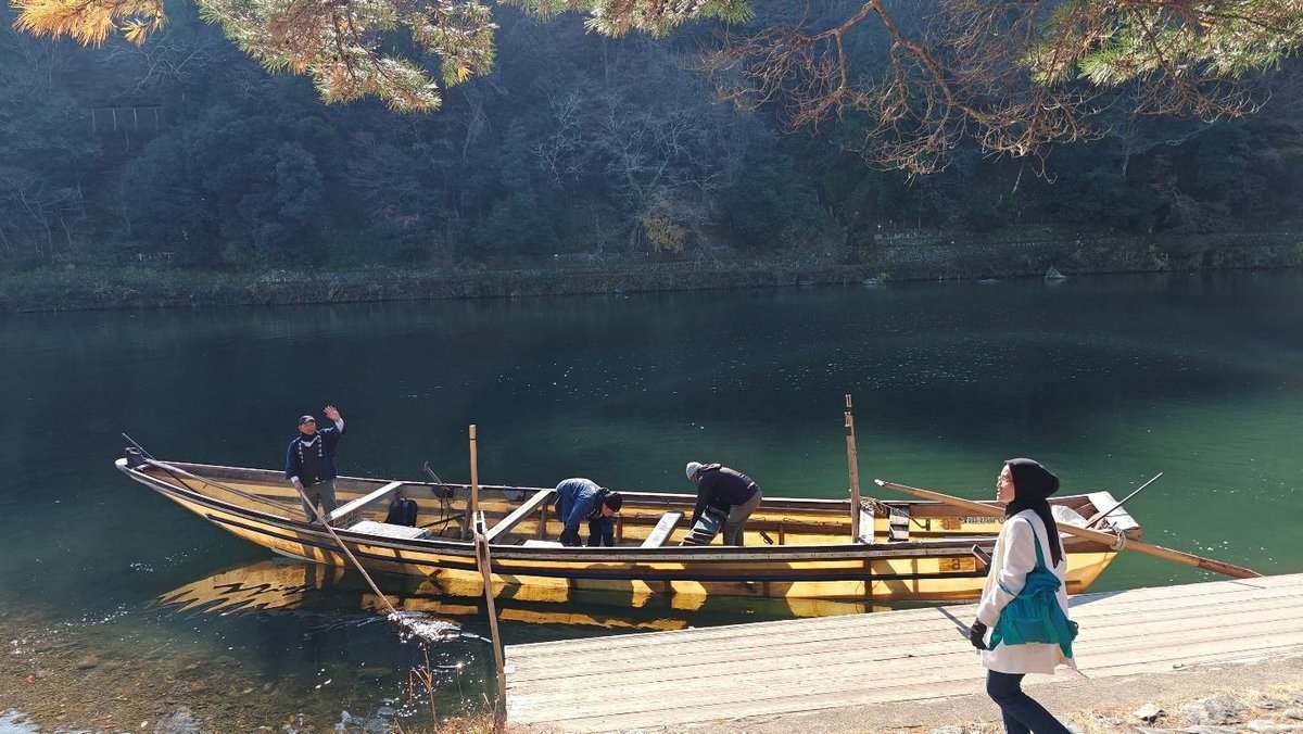 Wooden boat on serene lake with people and trees