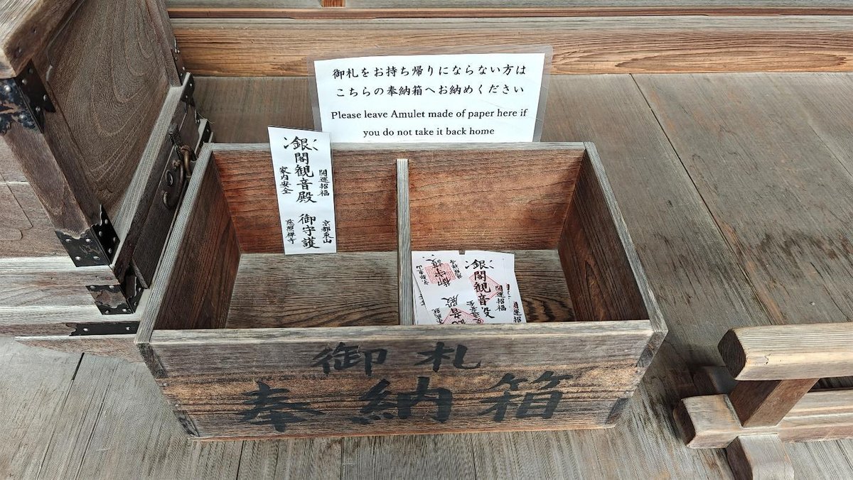 Wooden box with paper amulets and Japanese text sign