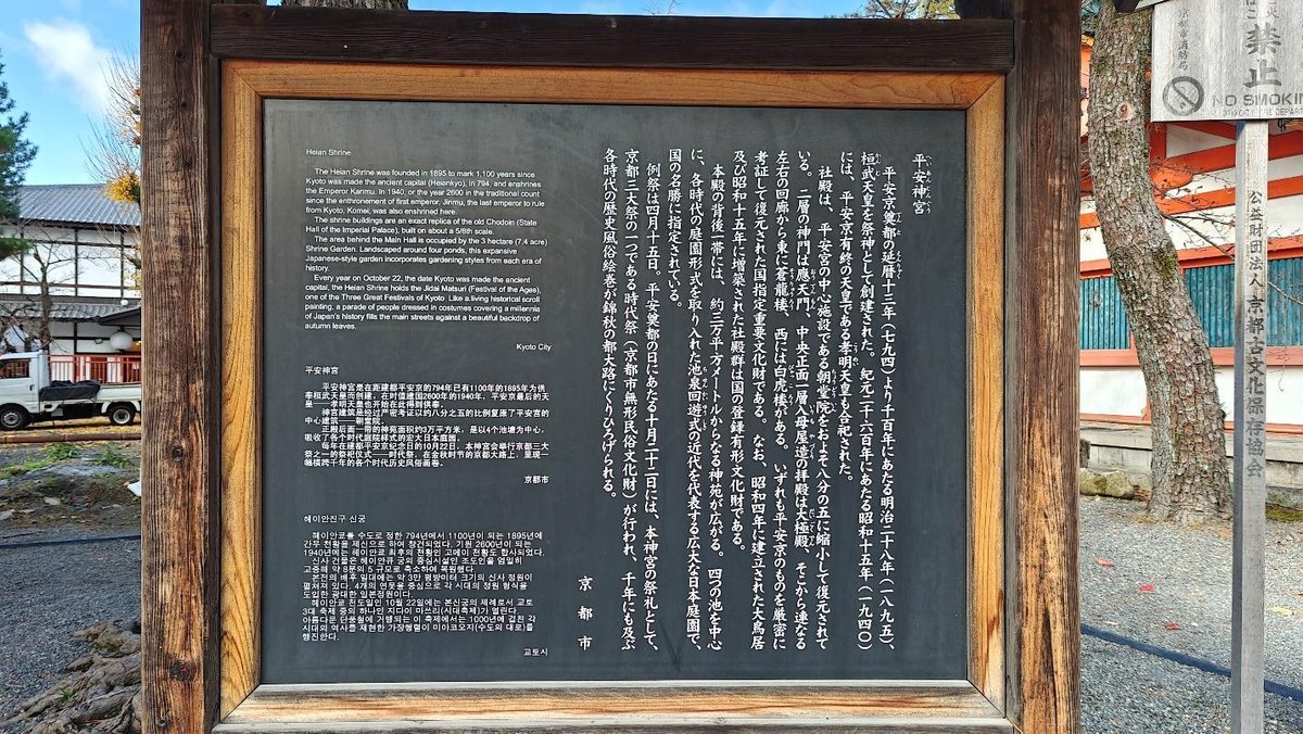Wooden sign with multilingual text near outdoor shrine