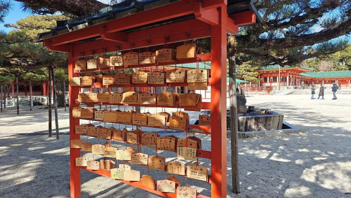 Wooden wish plaques at a shrine with traditional red buildings
