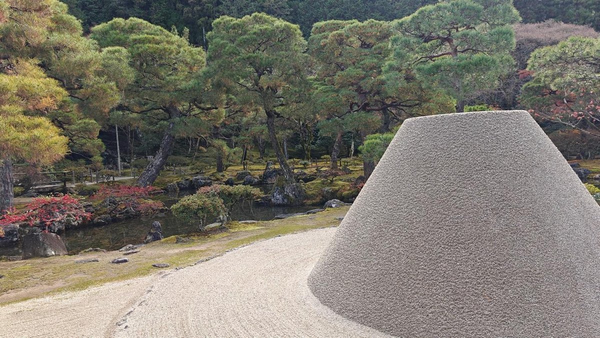 Zen garden with gravel cone and lush green trees