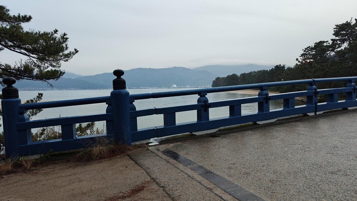 Blue bridge with mountain and sea view under cloudy sky