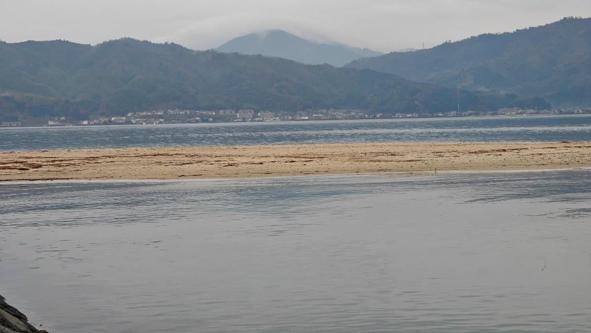 Calm sea with distant misty mountains