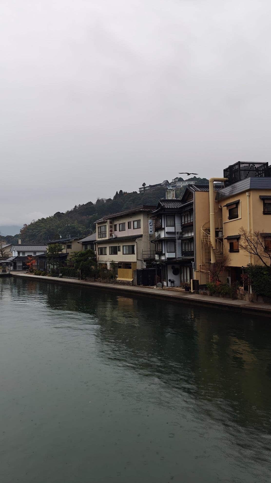 Canal-side houses under cloudy sky in scenic landscape