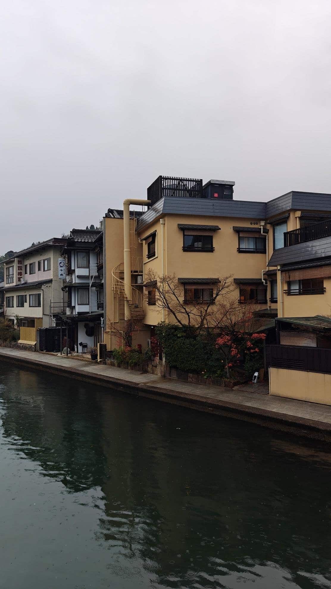 Canal with residential buildings under overcast sky