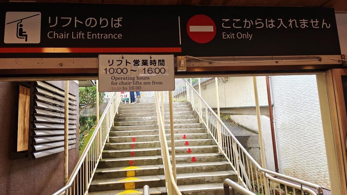 Chair lift entrance with signs and staircase