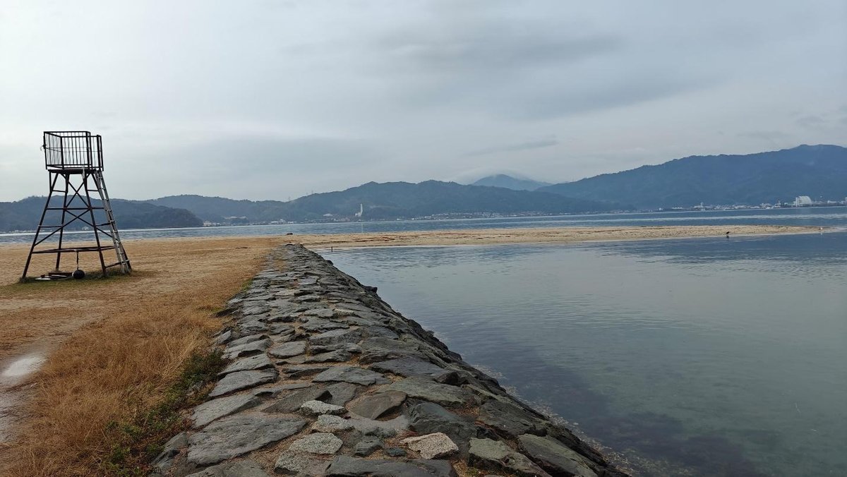 Coastal scene with mountains and lifeguard tower