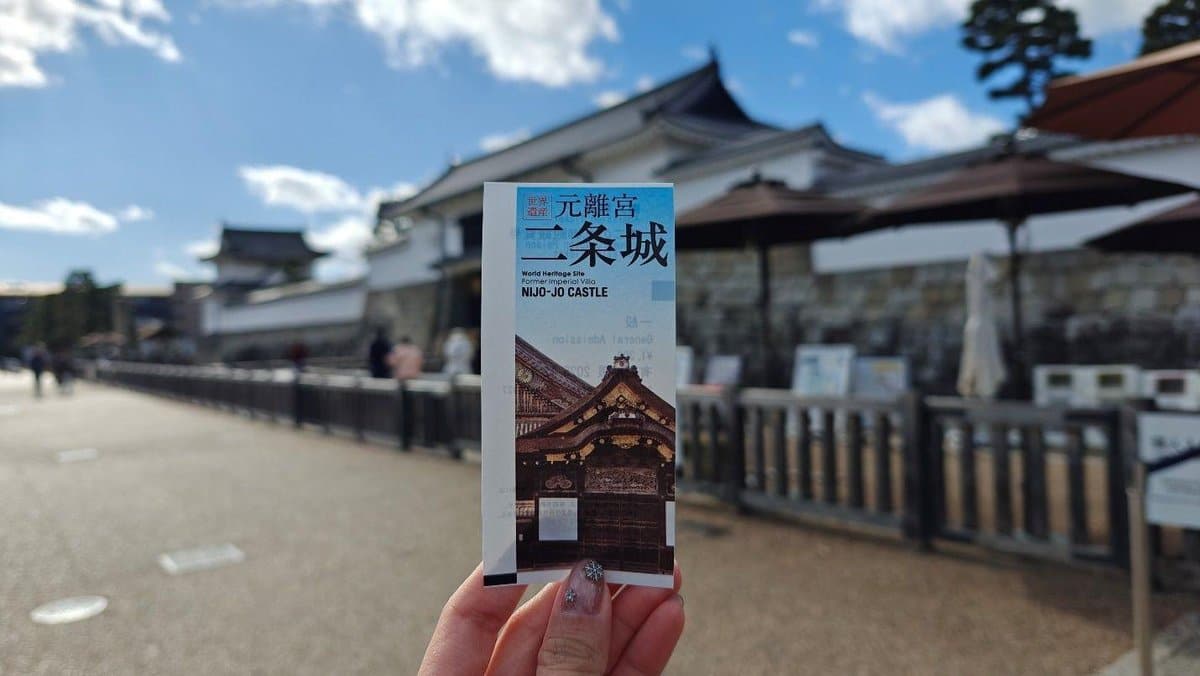 Hand holding Nijo Castle ticket, blurred view