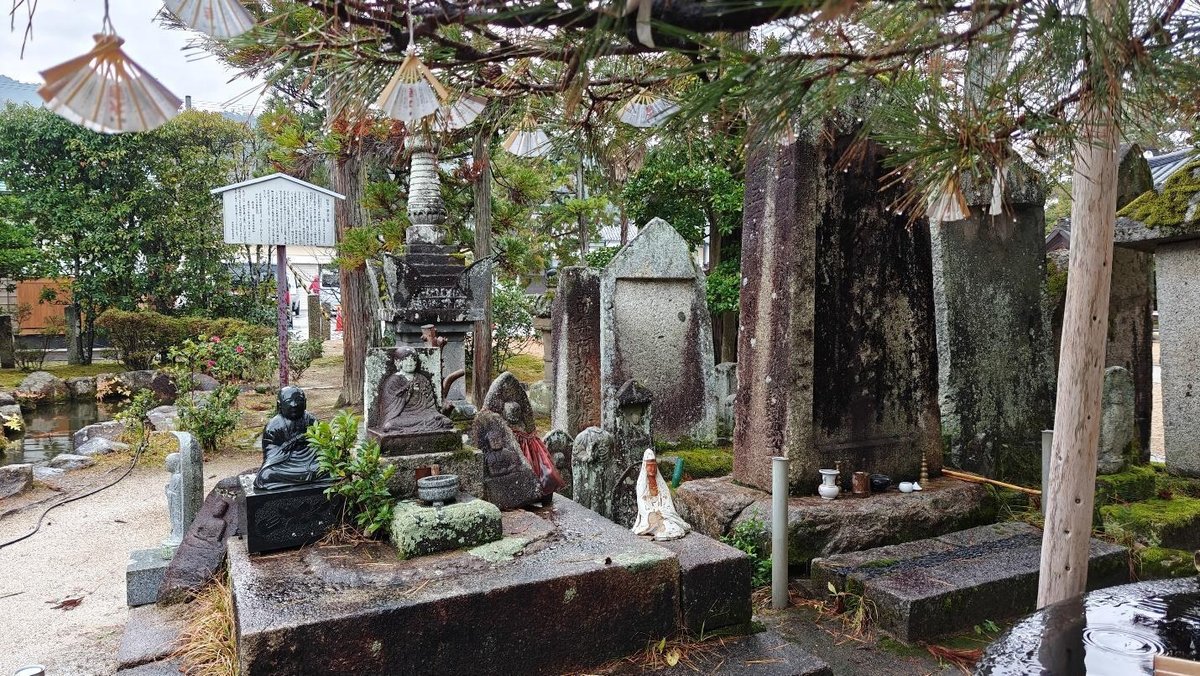 Historic stone statues and monuments in a tranquil garden setting.