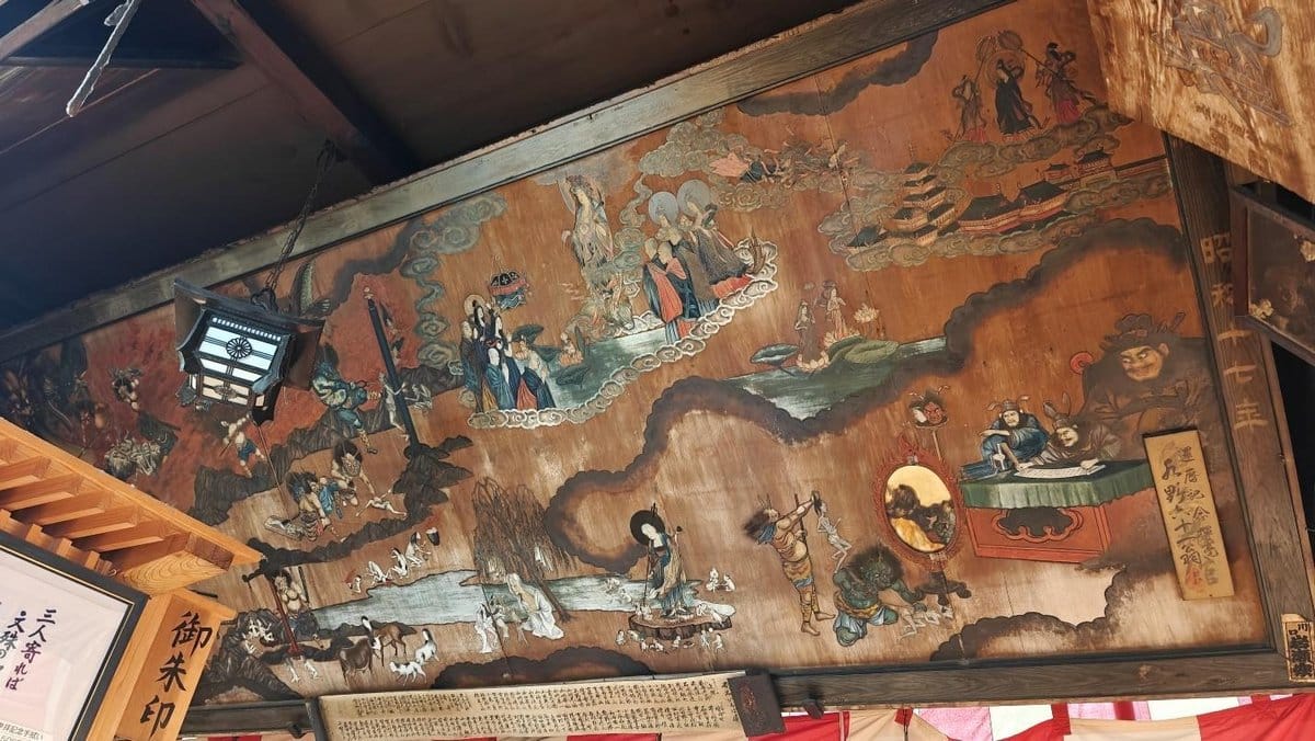 Intricate wooden ceiling art with mythical figures and landscapes