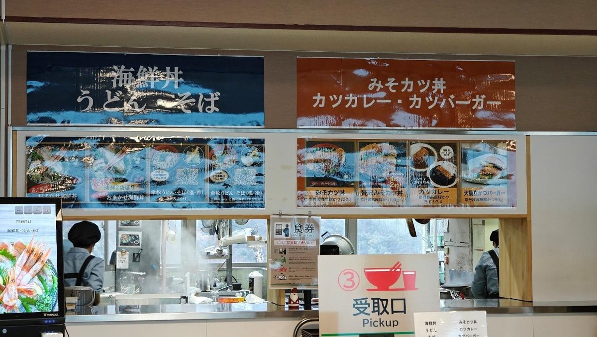 Japanese food stall with menu signs in a cafeteria setting