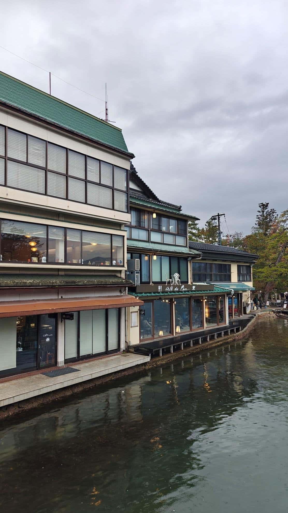 Lakeside café with large windows under cloudy sky