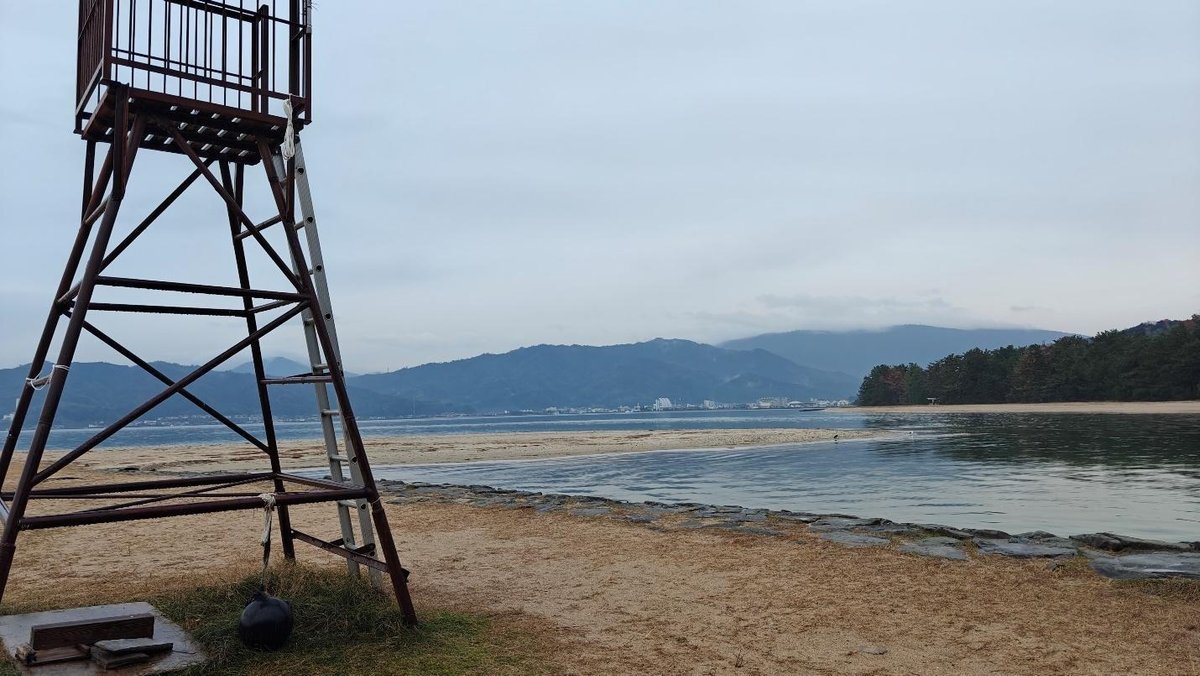 Lifeguard tower overlooking tranquil beach and distant mountains