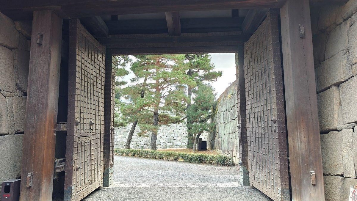 Open wooden gates with stone walls