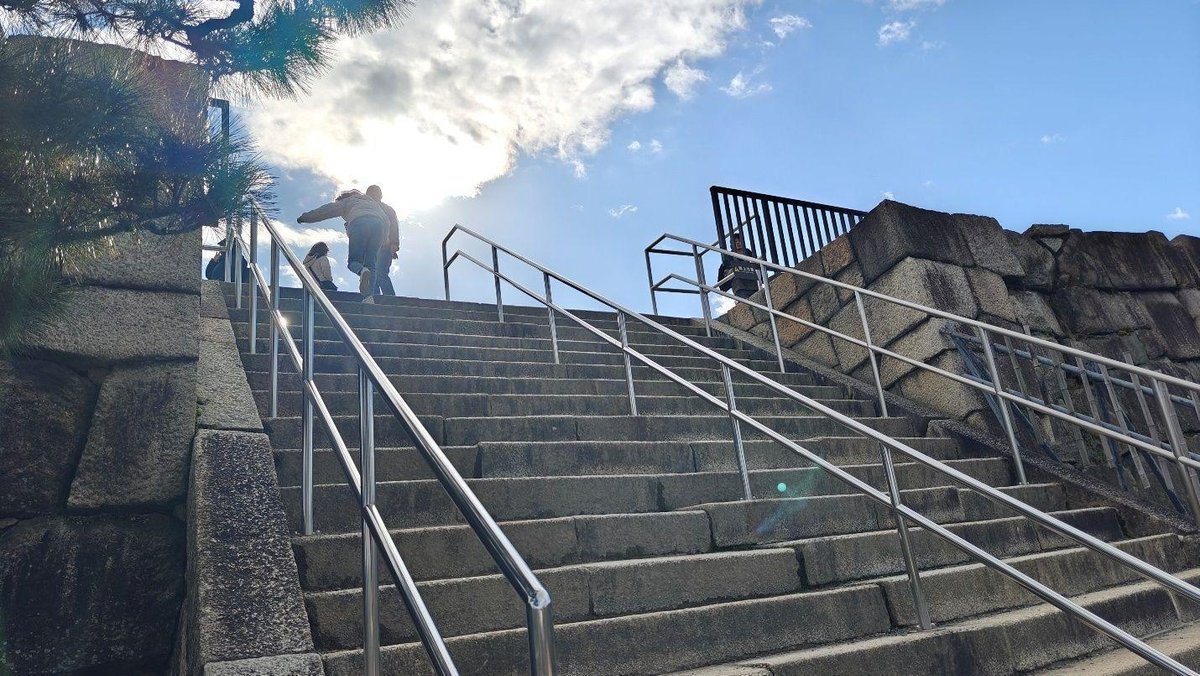 People ascending stone steps, sunny sky
