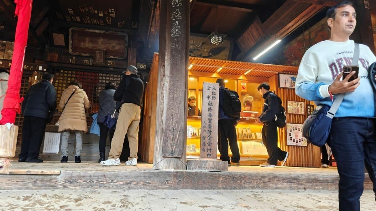 People at a Japanese temple wooden interior with vibrant lights