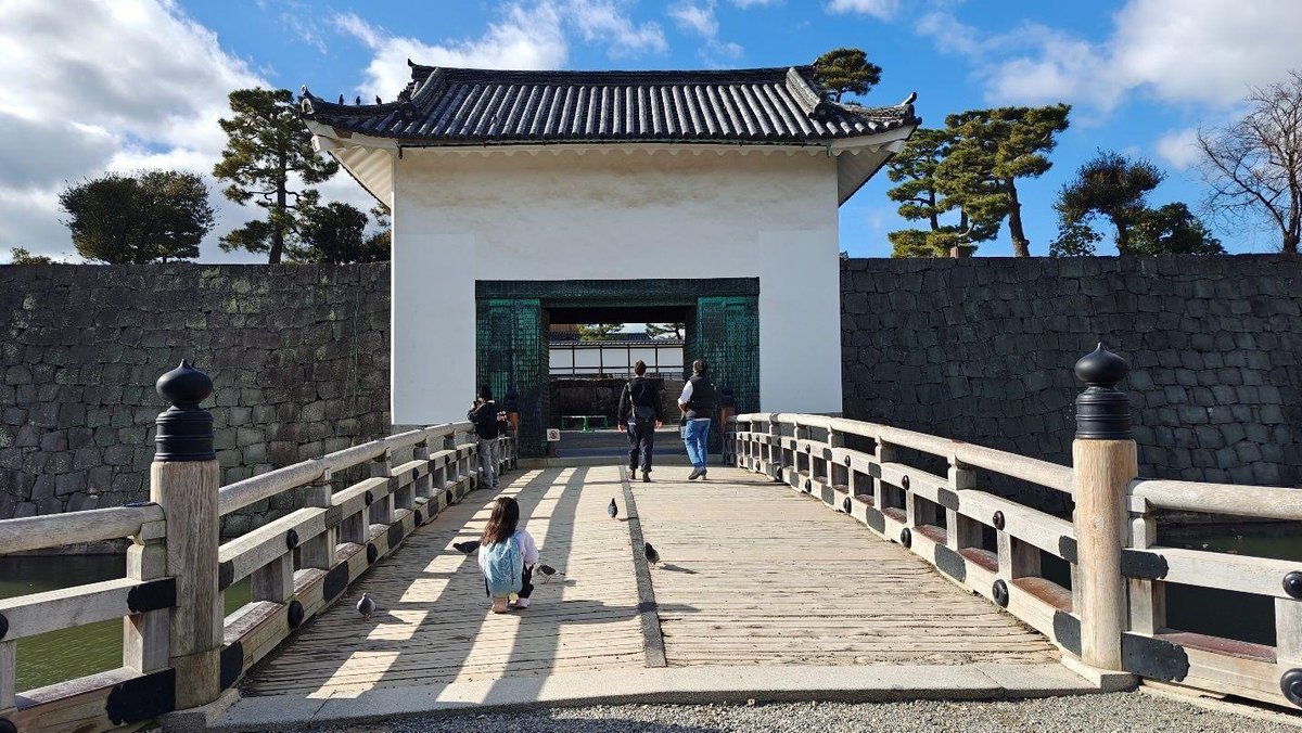 People on a bridge to traditional gate