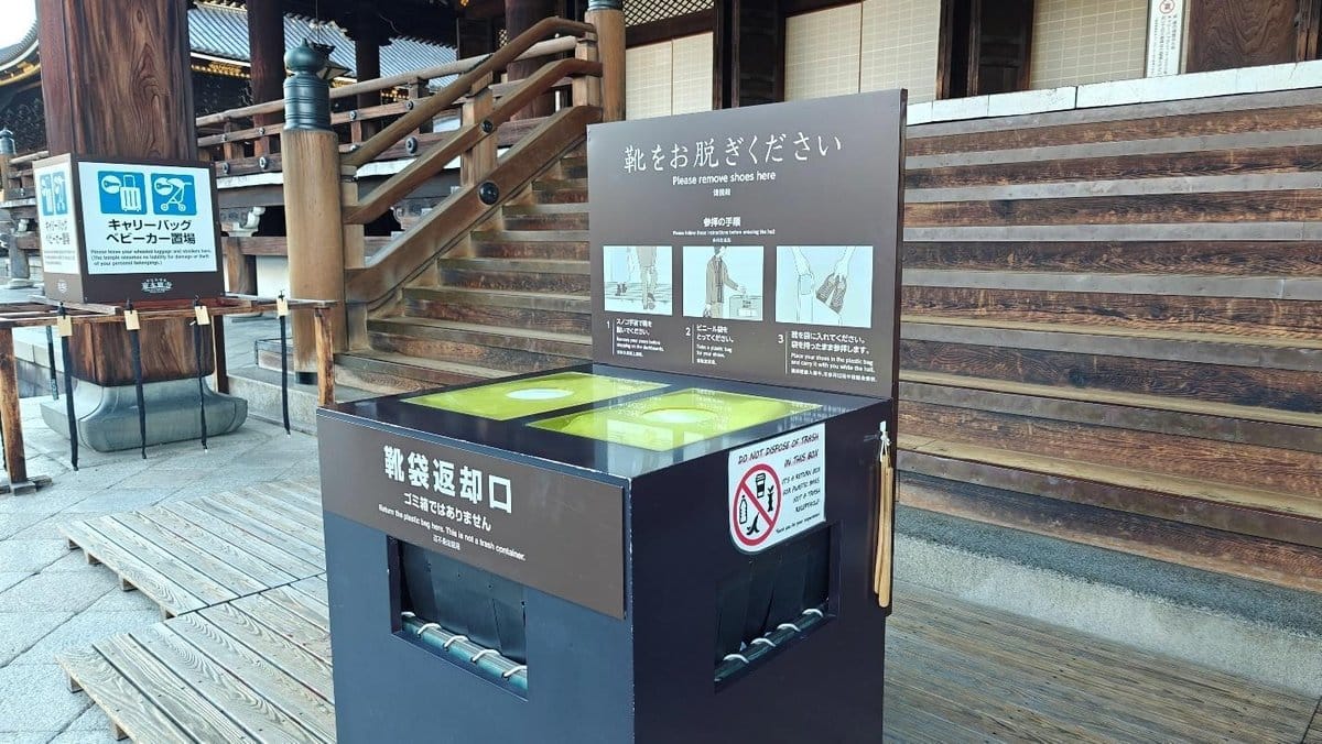 Shoe removal area at wooden temple entrance with instructions
