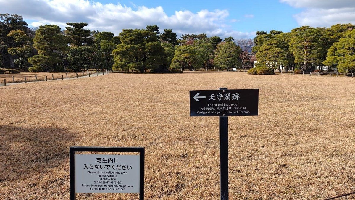 Signs in park with trees and pathway