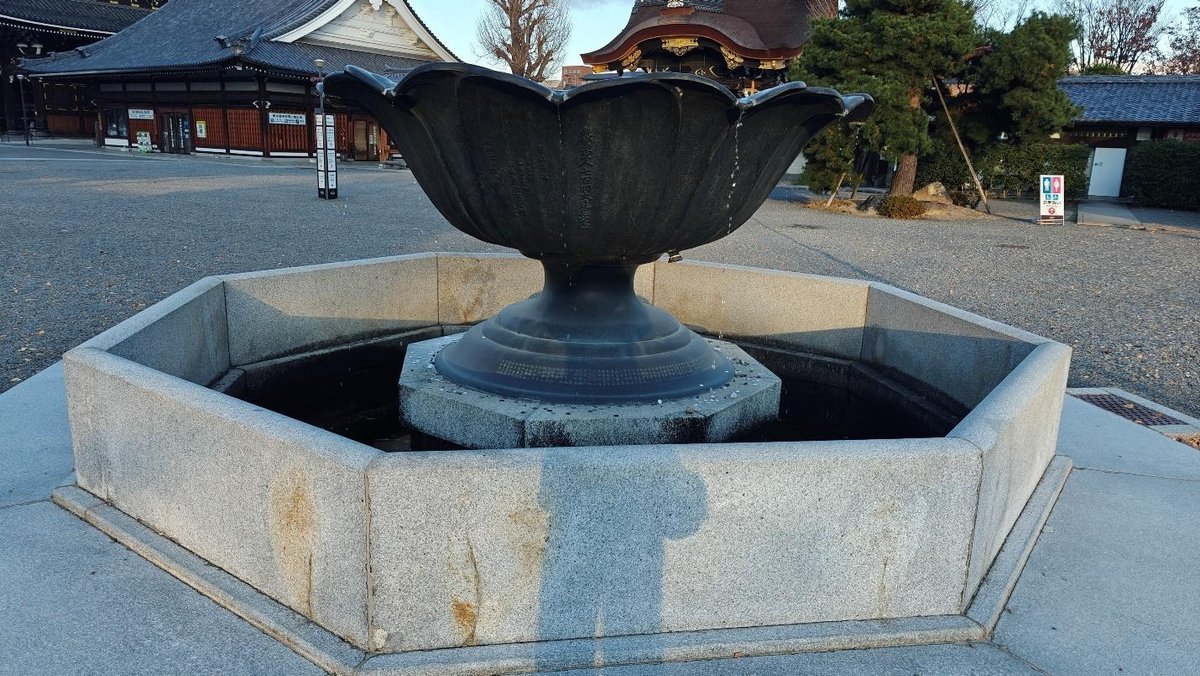 Stone fountain in front of traditional Japanese building