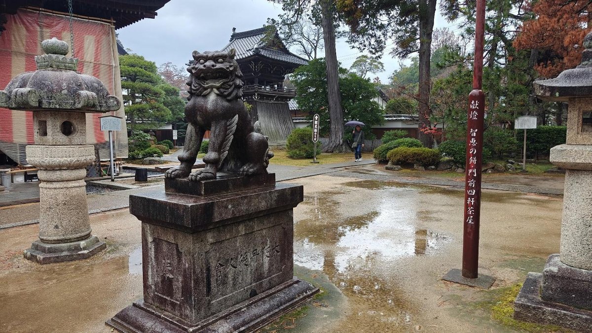 Stone lion statue in serene Japanese garden with pagoda