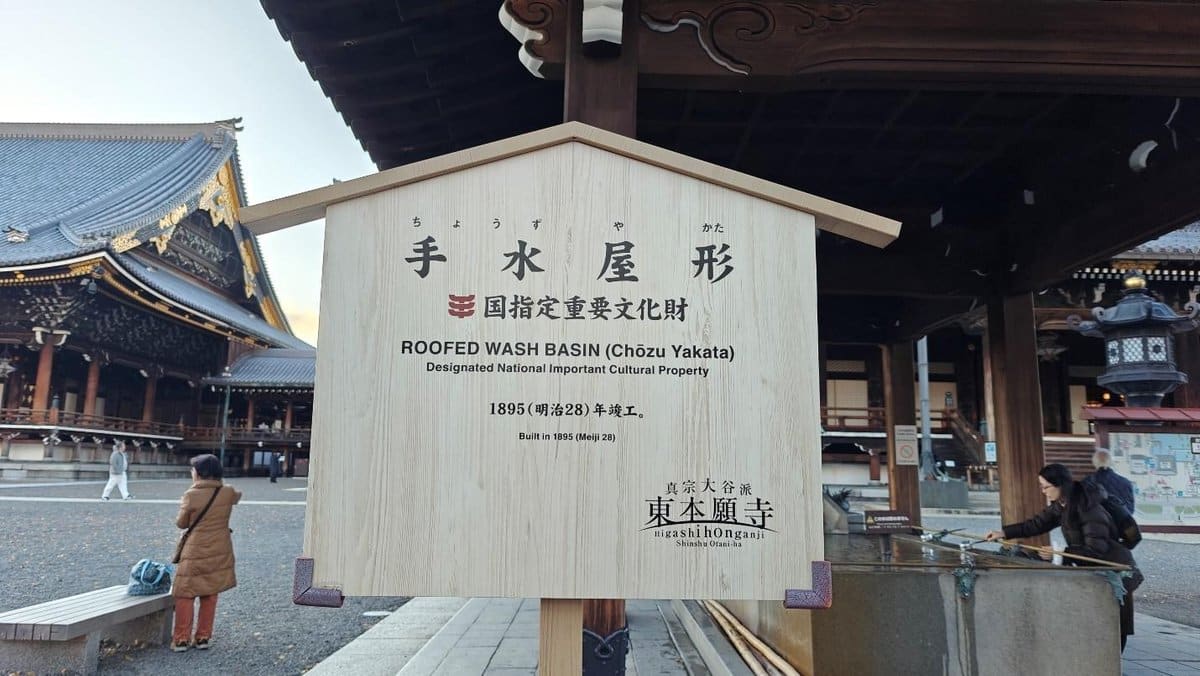 Temple roofed wash basin with visitors in traditional setting