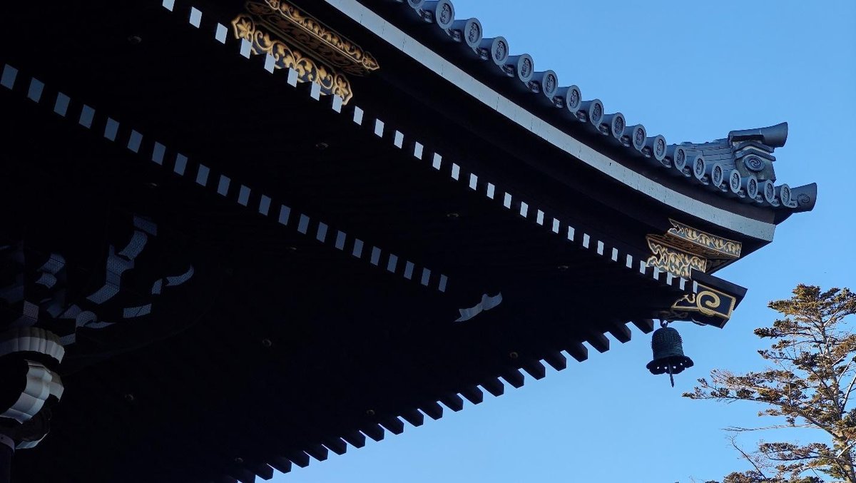 Traditional Asian roof with ornate details against blue sky