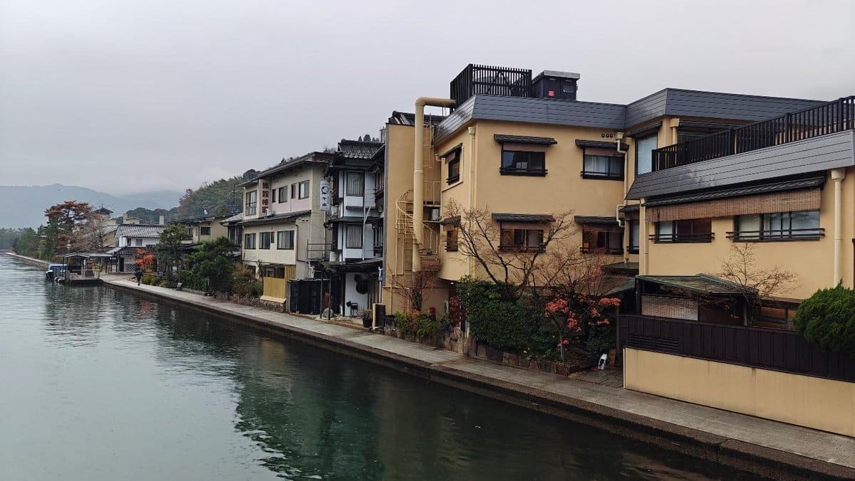 Traditional buildings by a tranquil canal on a cloudy day