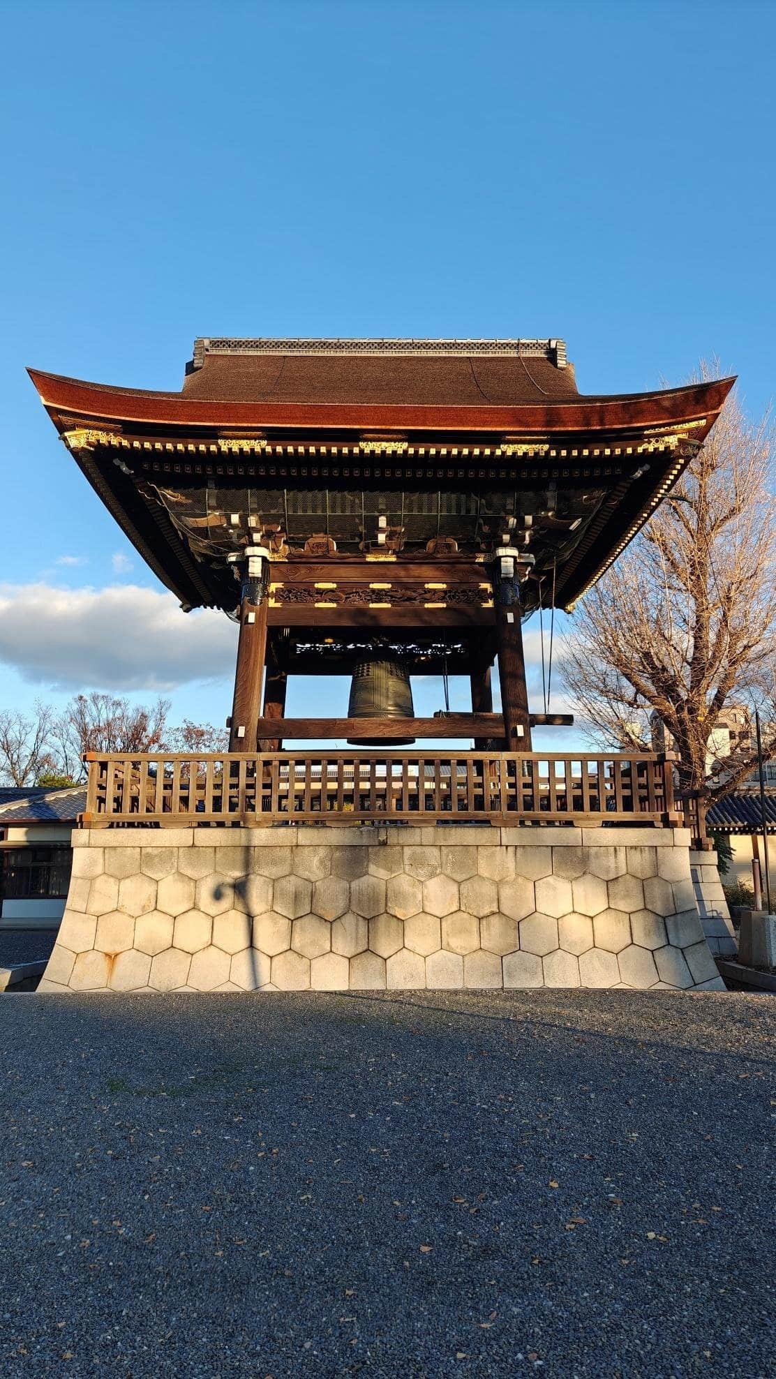 Traditional Japanese bell tower under clear blue sky