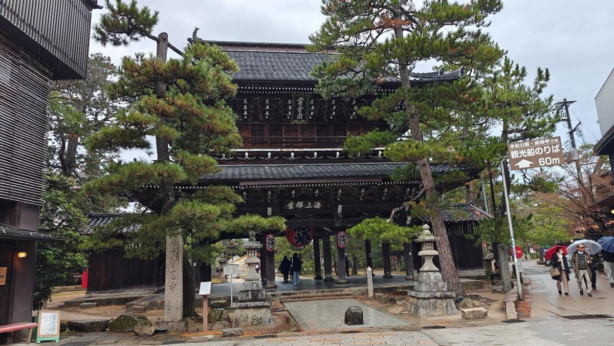 Traditional Japanese gate surrounded by pine trees