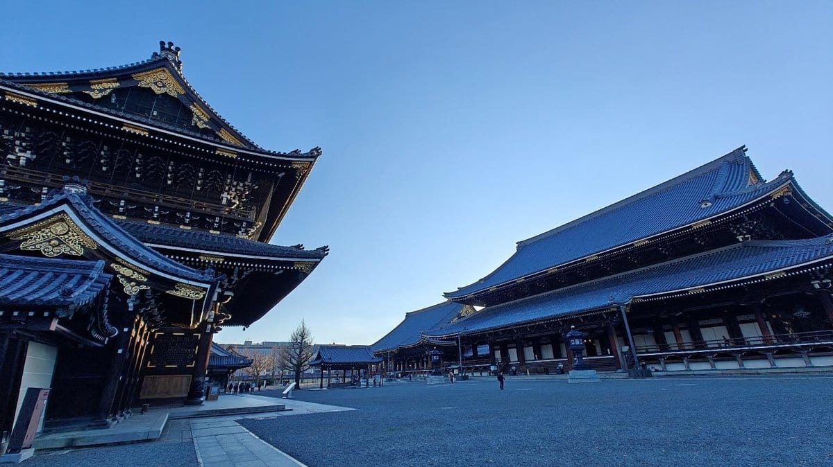 Traditional Japanese temple buildings under clear blue sky