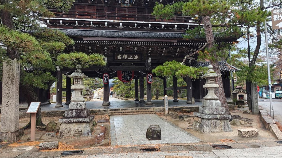 Traditional Japanese temple gate with stone lanterns