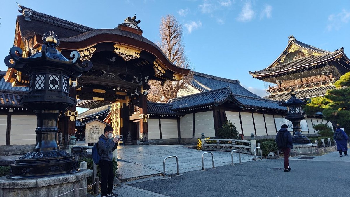 Traditional Japanese temple with ornate gate under blue sky