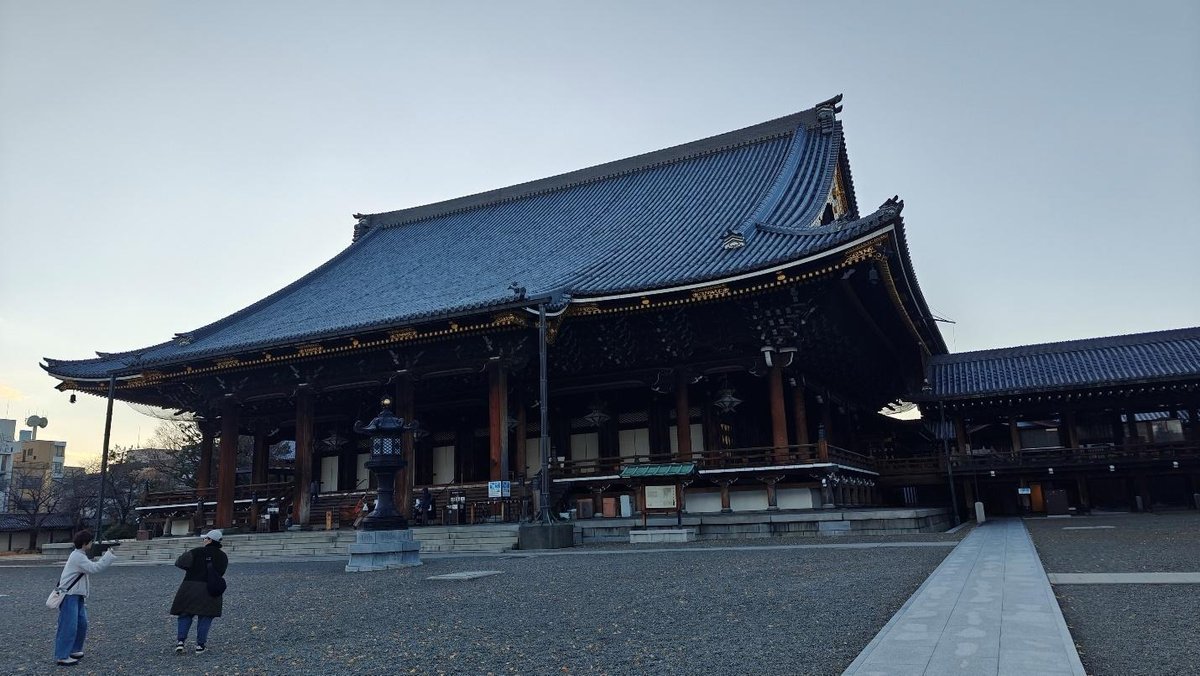 Traditional temple with intricate roof and two people outside
