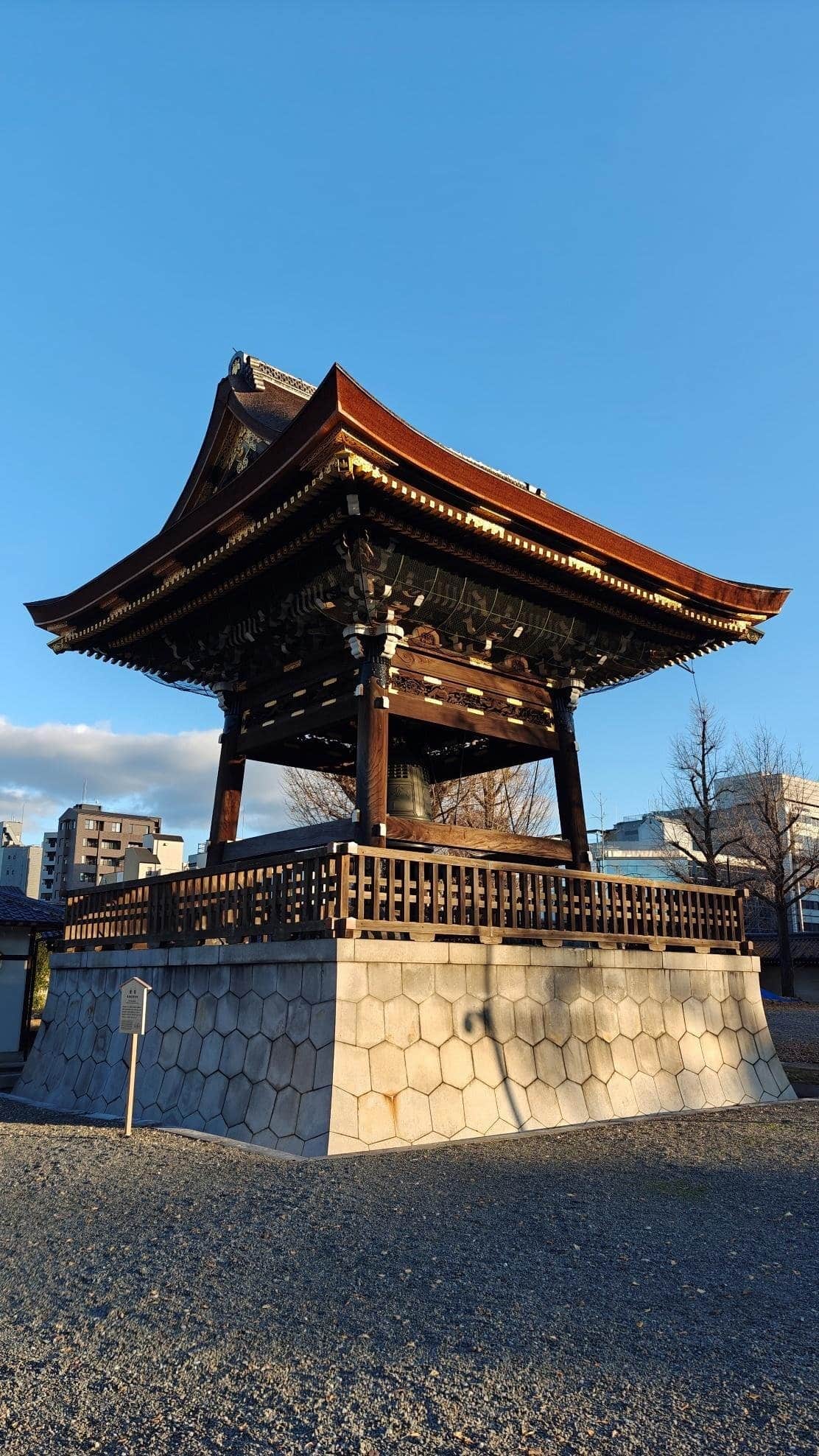 Traditional wooden bell tower under a clear blue sky