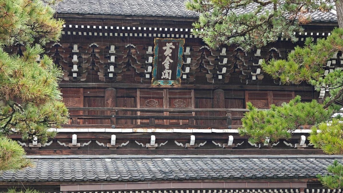 Traditional wooden Japanese temple facade with greenery