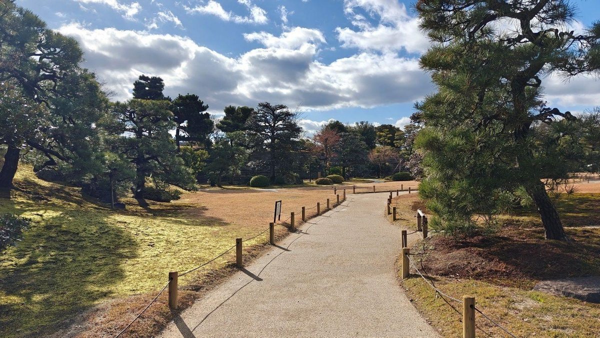 Tranquil park path with trees and clouds