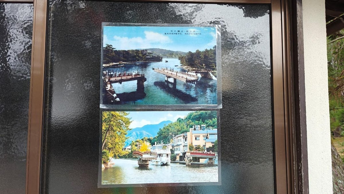 Two scenic postcards on dark glass panel