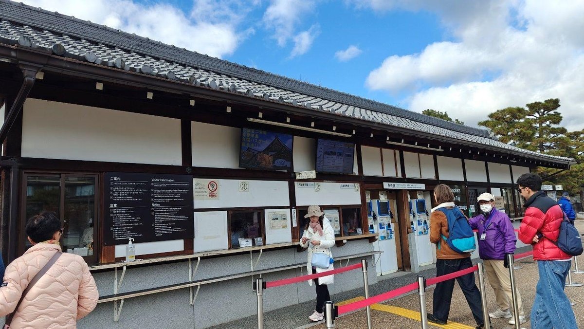 Visitors at a ticket booth queue